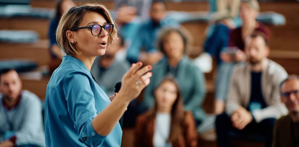 Women leading an talk at a convention as she gained the skills and qualifications through studying a Master's in Educational Leadership