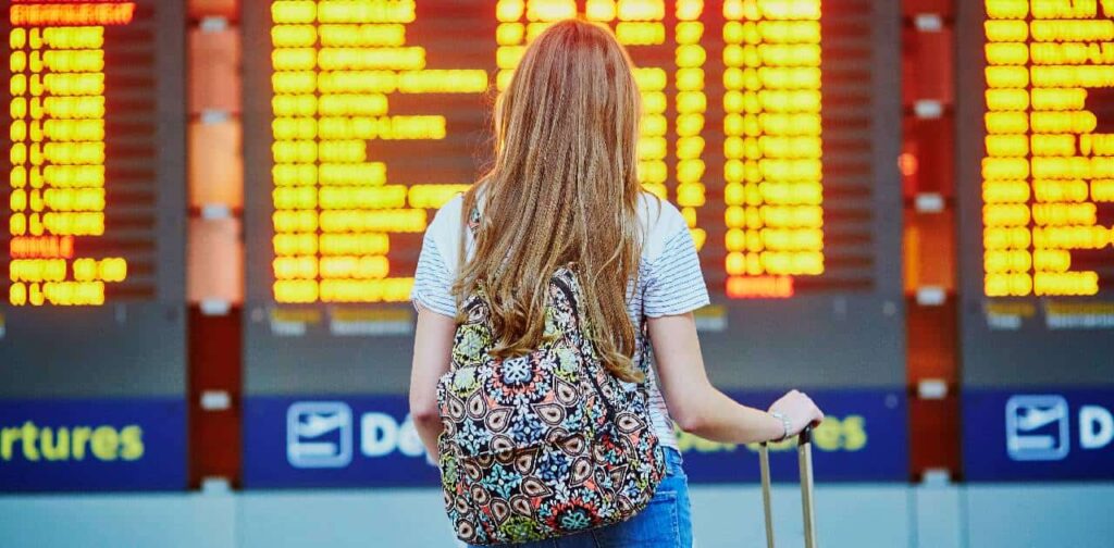 Female teacher with backpack in international airport waiting to start her new teaching career abroad